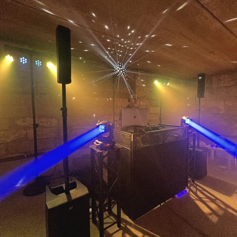 DJ-Kabine mit Moving Heads und blauen Lichtstrahlen unter einem Steingewölbe auf einer Finca auf Mallorca