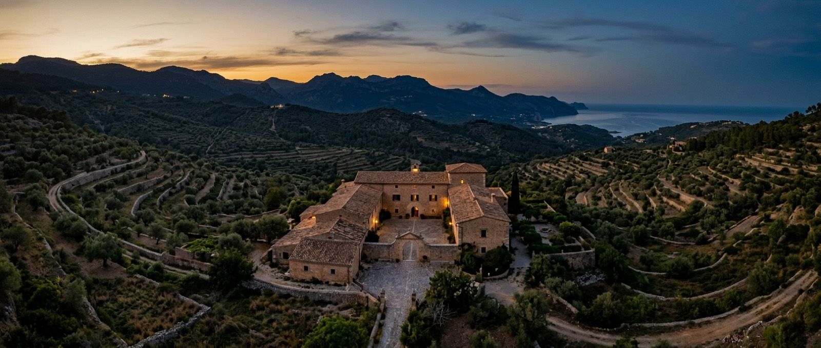 Terrasse einer mallorquinischen Finca bei Sonnenuntergang, für eine Veranstaltung eingedeckt, mit Blick auf das Gebirge